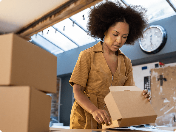 Homme tirant des colis sur un chariot dans un centre d’expédition Amazon avec une illustration superposée d’une liste de stock