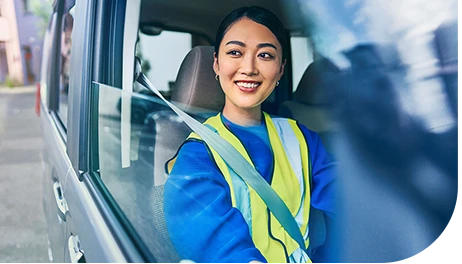 配達パートナーが安全ベストを着用して車の運転席に座っている様子