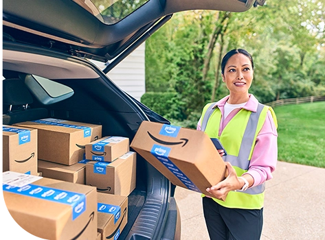 Delivery woman in safety vest  with Amazon packages at her trunk