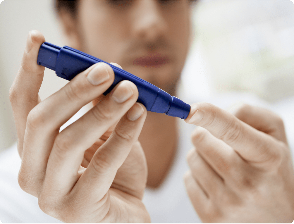 Blood glucose test Man uses a lancet to test his blood glucose levels
