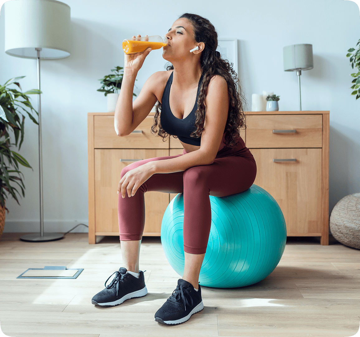 Woman Completes Exercise Woman completes exercise and drinks a juice