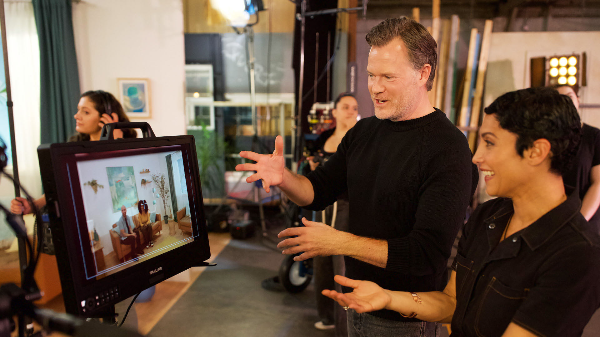 IMDbPro image of a set designer and director looking at a monitor on a film set