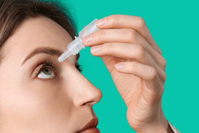 Woman applies antibiotic eye drops for pink eye symptoms