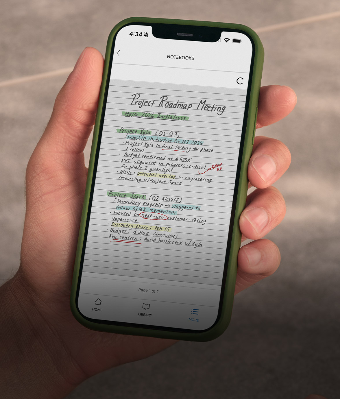 A hand holds a smartphone with the Kindle app open to “Project Roadmap Meeting.” Handwritten updates for Xyla and Spark include color highlights. A cup of espresso and pastry sit on the table.