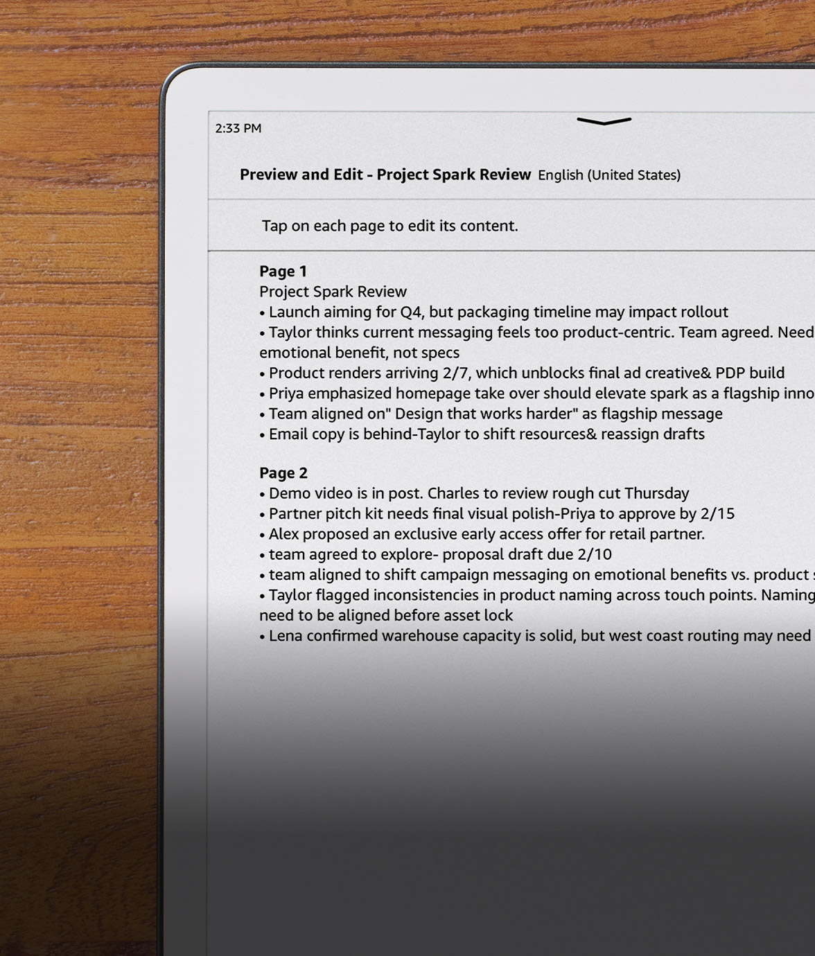 Kindle Scribe on a wooden desk displaying a typed document titled “Project Spark Review,” with multiple pages of notes and bullet points visible on screen.