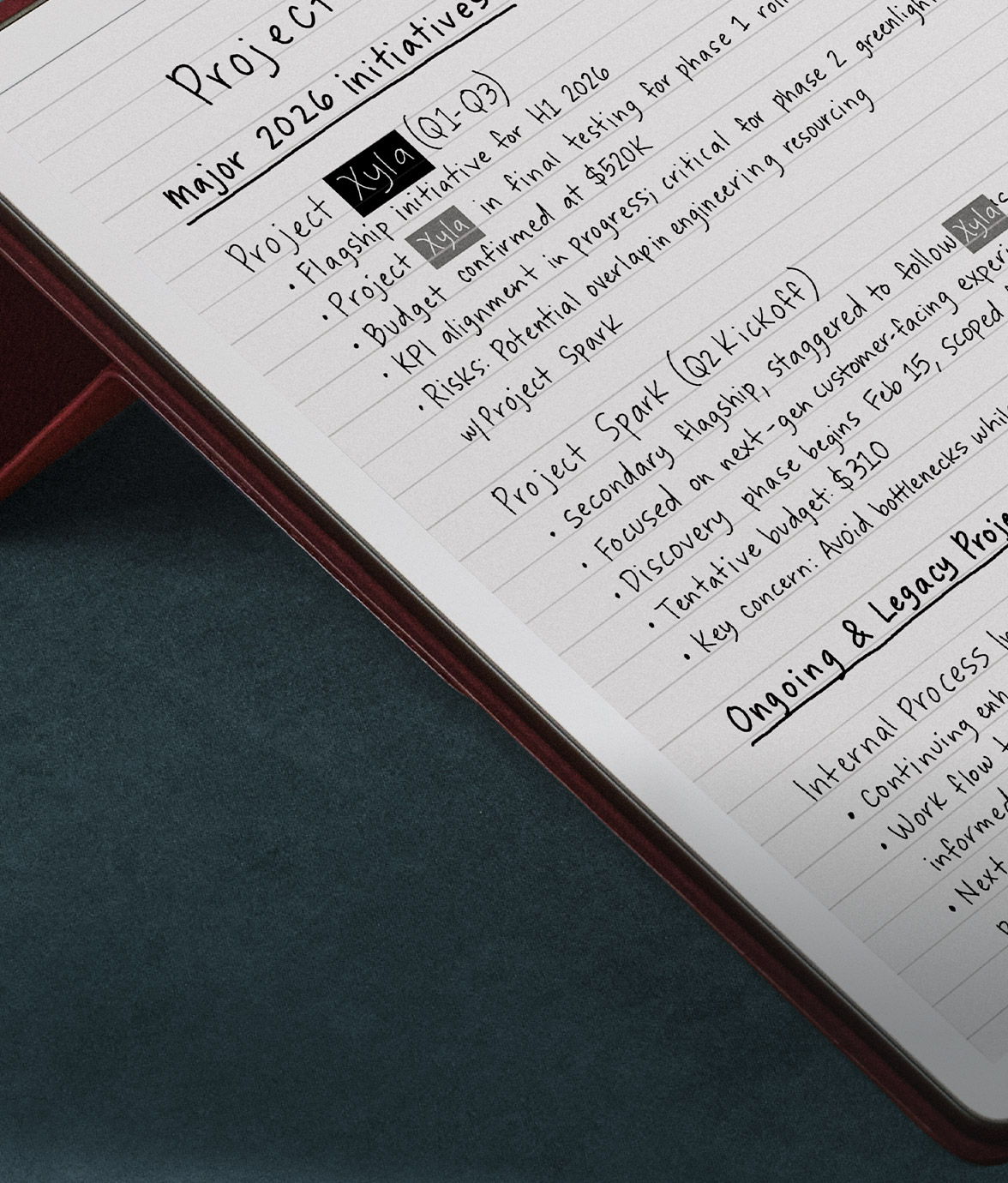 Close-up of Kindle Scribe on a desk with handwritten notes outlining a project roadmap, highlighting “Project Xyla” as a key initiative.