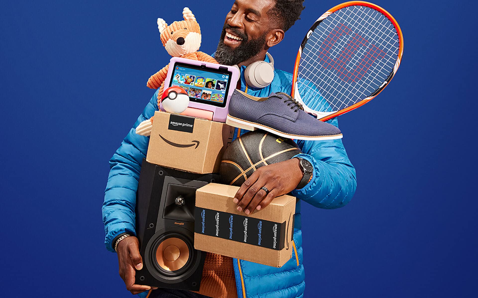 A man holding a lot of items and boxes in his arms.