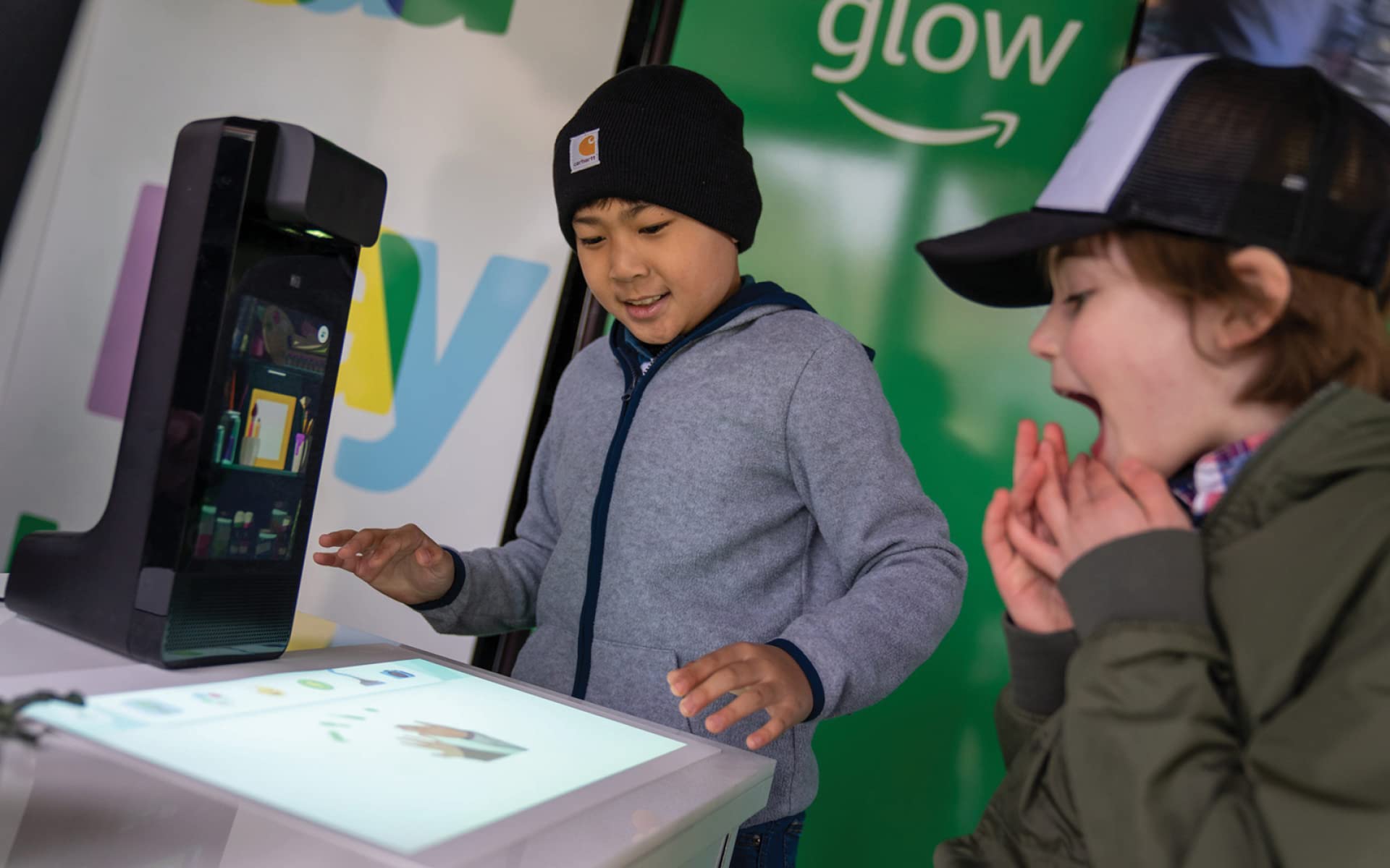 Two boys playing with an Amazon Glow device