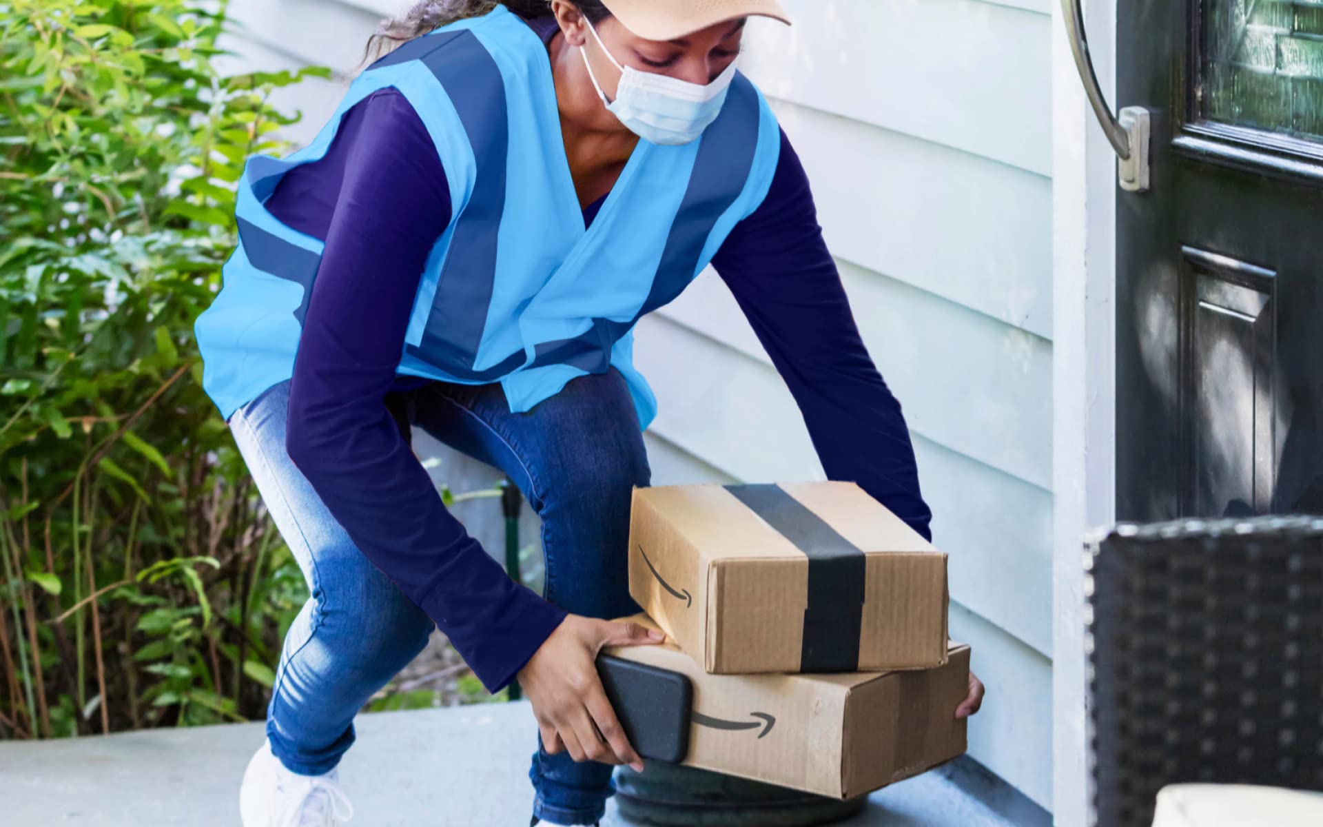An Amazon employee delivering packages to a home