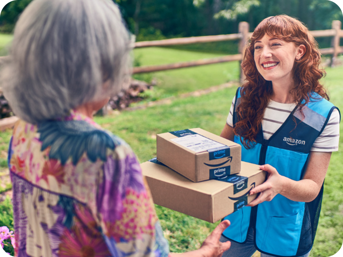 Amazon delivery driver in branded vest hands two packages tocustomer at residential location.