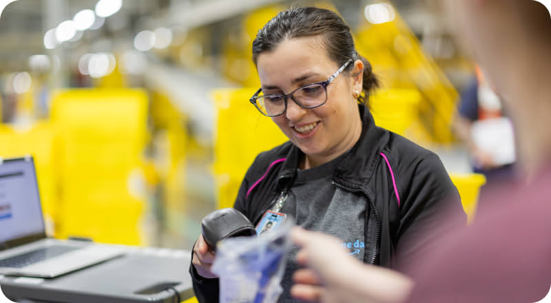 Female associate scanning an image and smiling while in a warehouse.