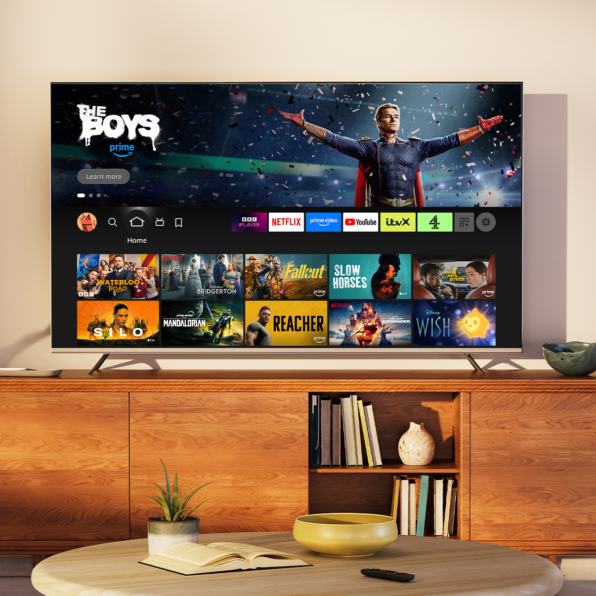 A close shot of a TV in a living room during the day. The Fire TV main menu is on screen, with Masters of the Air as the selected title.