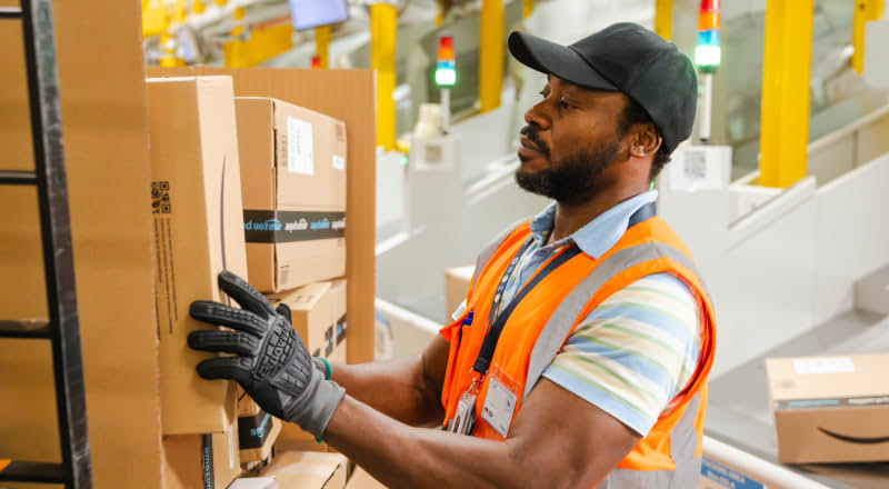 Amazon sortation operative scanning and handling packages in warehouse