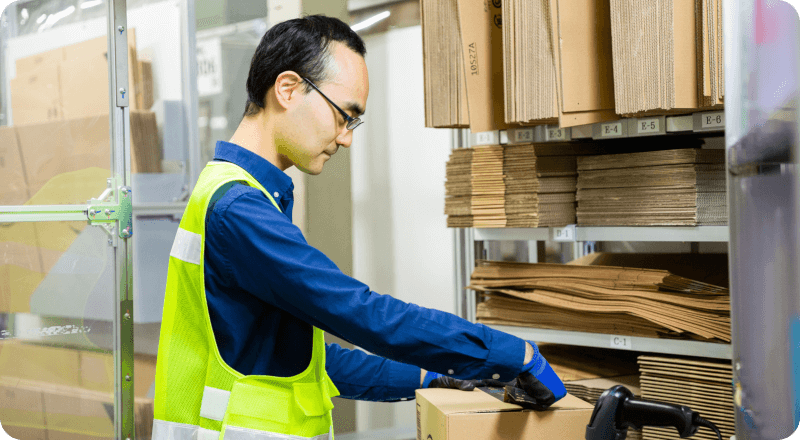 倉庫スタッフが、お客様への出荷に向けてAmazonの荷物を丁寧に梱包しています。