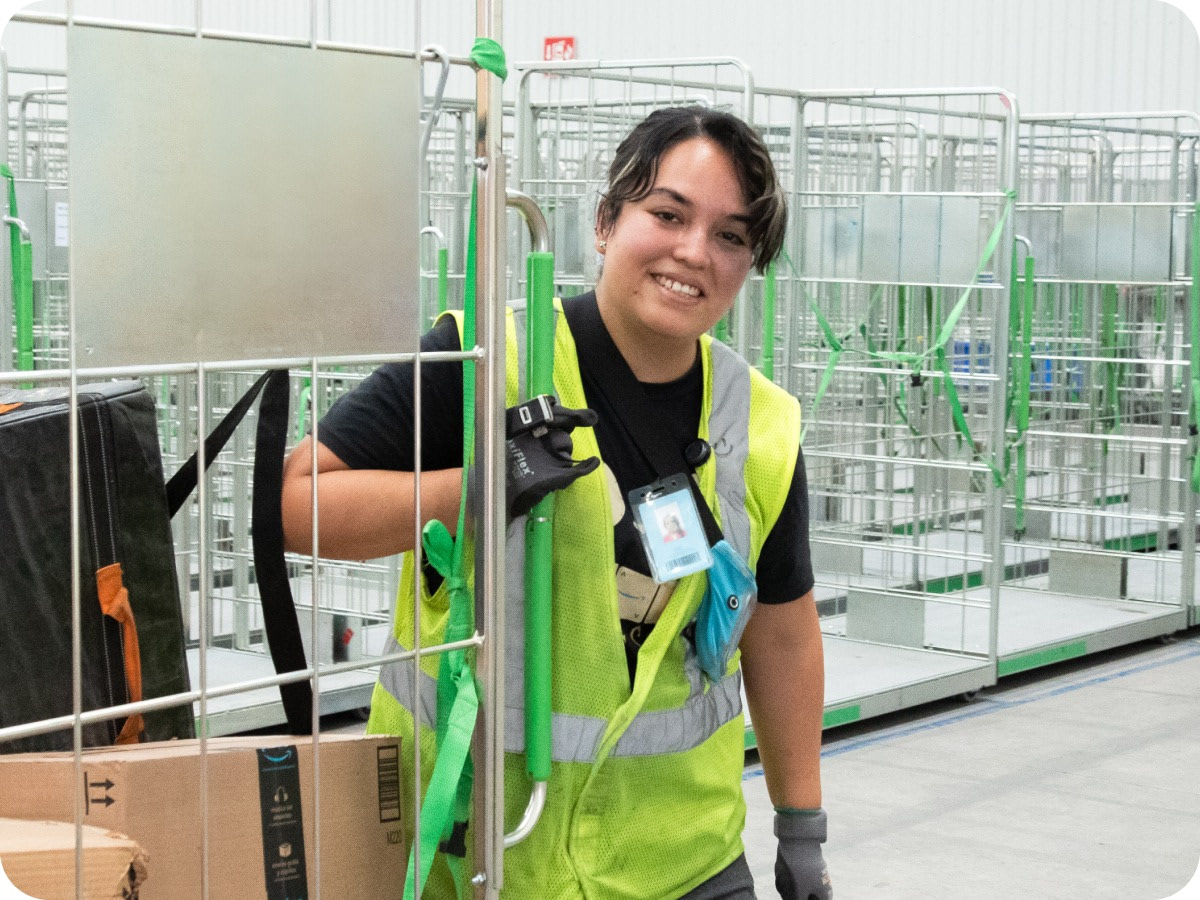 Colaborador usando colete de segurança sorri no centro de distribuição
