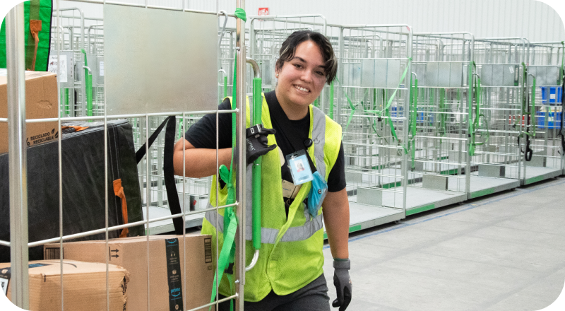 Associate in safety vest with scanning device smiles in fulfillment center