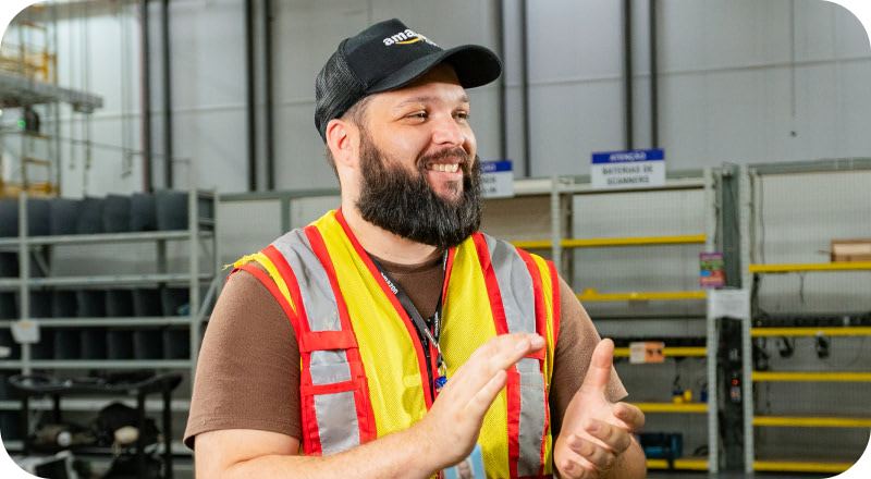 Associate in safety vest smiling and giving thumbs up in fulfillment center