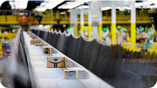 Pacotes Amazon sendo processados em linha de produção automatizada