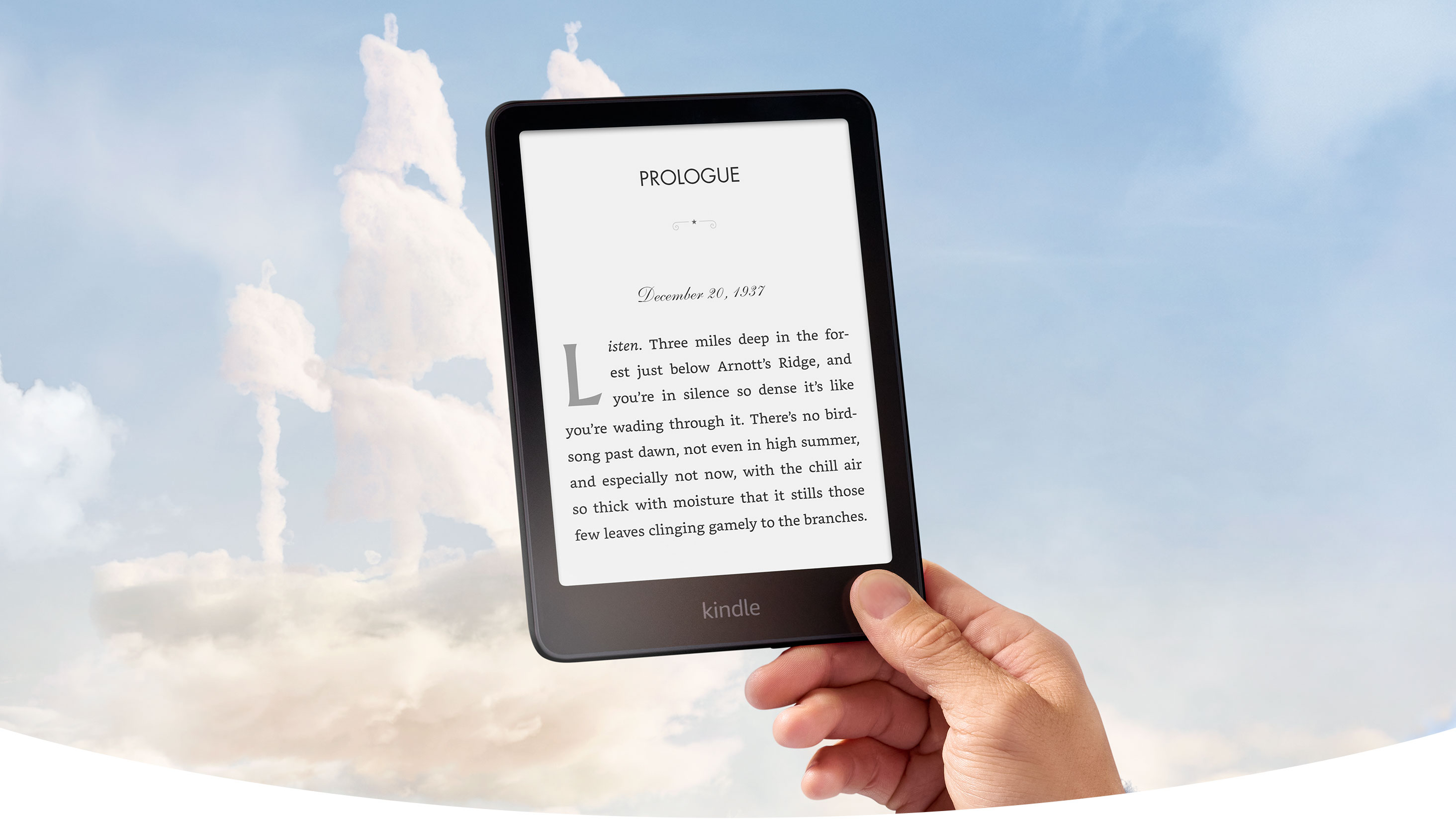 A hand holds Kindle Paperwhite Signature Edition against a blue sky. The clouds are shaped like a pirate ship. A chapter book is on screen.