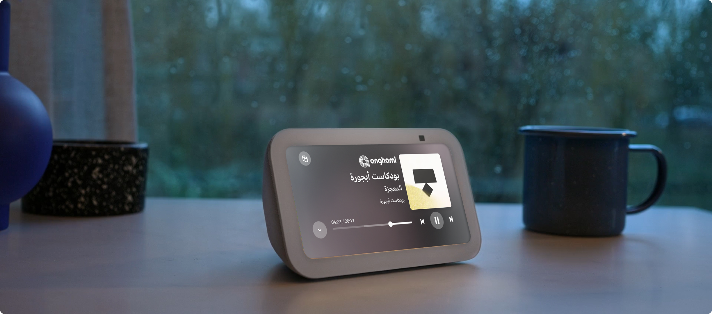 جهاز Echo Show 5، هو سماعة مع شاشة بمقاس 5 بوصات مزودة بمكبر صوت شبكي مستدير في الخلف وكاميرا و3 أزرار بارزة في الأعلى. يقع على طاولة وتظهر أغنية يتم تشغيلها على الشاشة عبر تطبيق للموسيقى.
