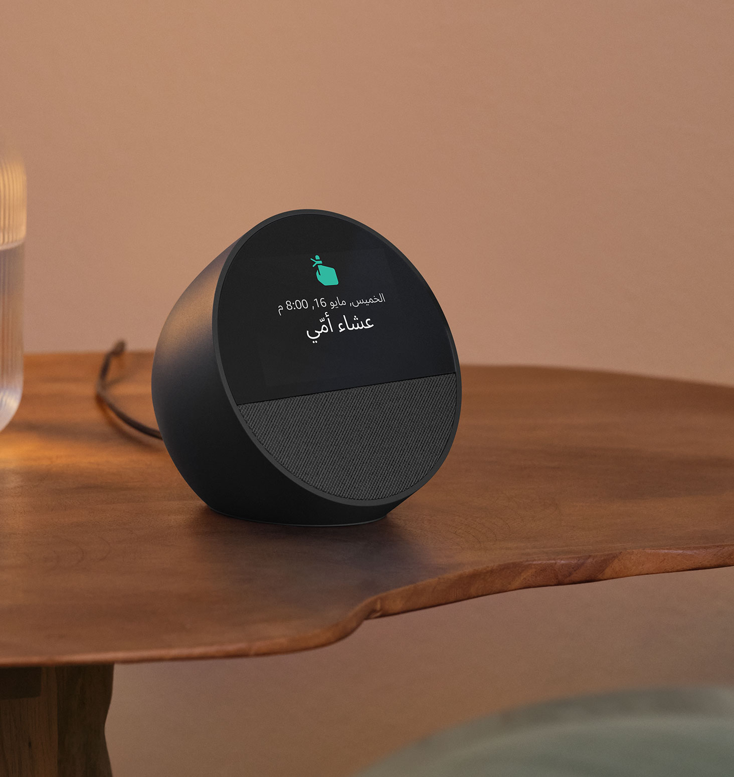 جهاز Echo Spot على طاولة بجانب السرير. تعرض الشاشة بحجم 2.8 بوصة التذكير "الساعة 10:00 الصباح تمرين يوقا مع دان" وأيقونة أصبع تؤشر للتذكير.