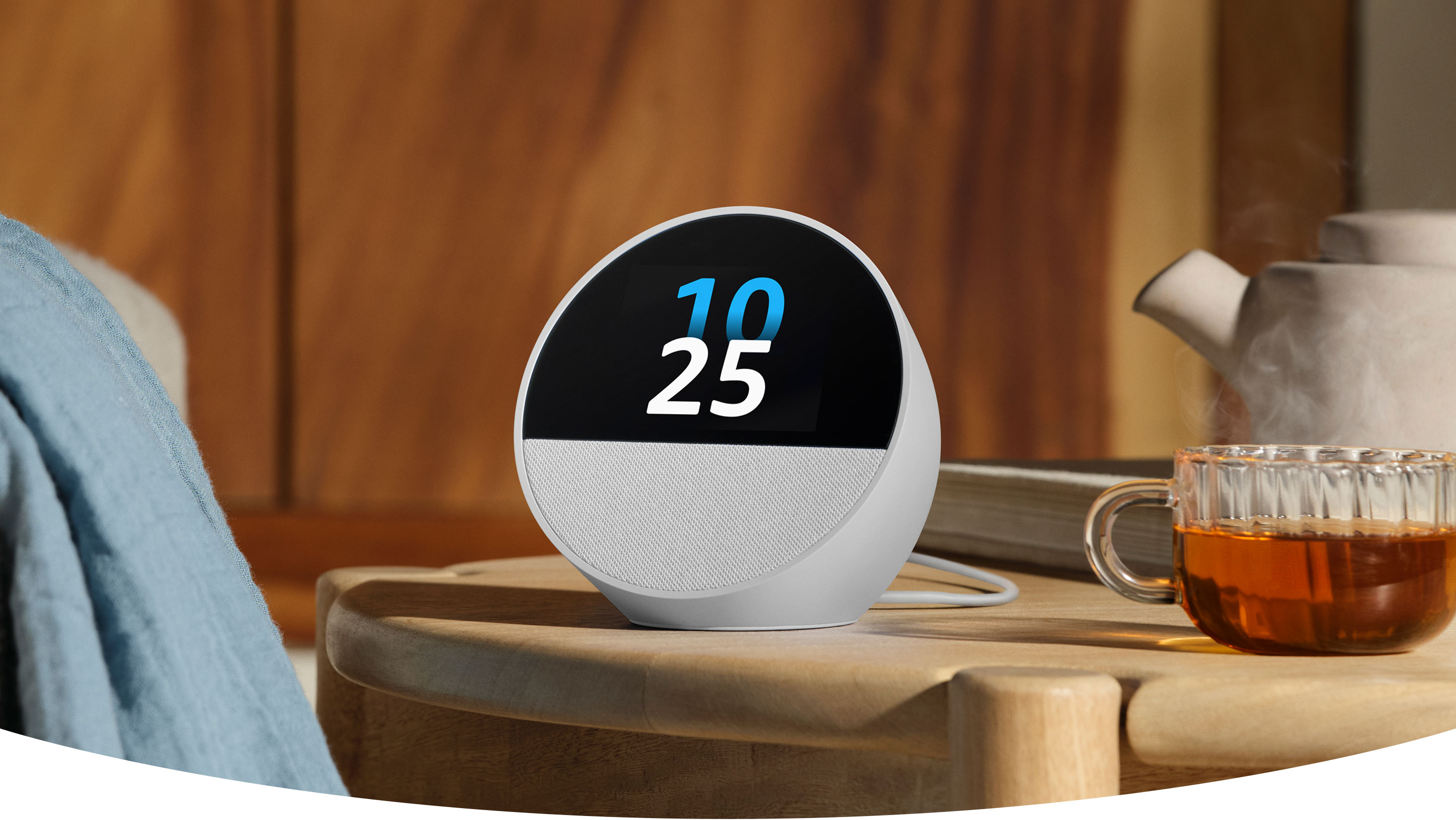 جهاز Echo Spot هو سماعة شبه كروية بشاشة لمس بحجم 2.8 بوصة وسماعة شبكية في الأسفل موضوع على طاولة سرير جانبية. تظهر  شاشة العرض الوقت وأيقونة المنبه ومنبه للساعة 7 صباحاً.