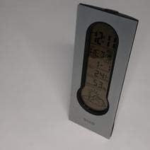 Front view of the BMW Multi-Function Clock display showing time, temperature, and weather icons.