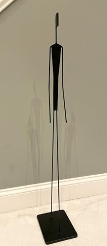 Tall thin minimalist metal figure sculpture standing on a small round base