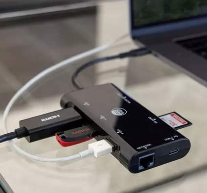 Various peripherals including a USB flash drive, HDMI cable, and SD card connected simultaneously to the UltraPro Elite USB-C Multiport Hub
