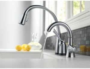 Delta Faucet Pilar 980T-DST installed in a kitchen sink, showing water flowing from the spout.