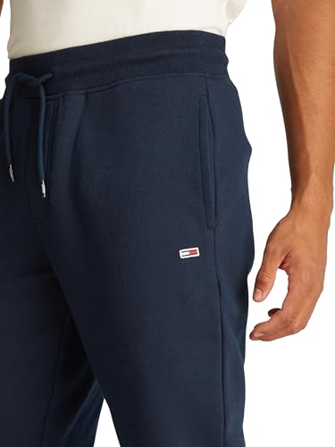 Detalle de los pantalones de chándal Tommy Jeans mostrando el logotipo y la textura del material en color azul marino