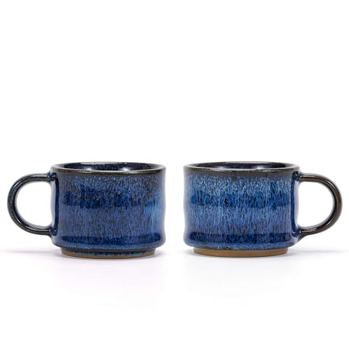 Two small blue ceramic espresso cups sitting side by side on a saucer