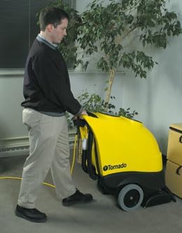 A person operating the yellow and black Tornado Marathon 1200 carpet extractor on a carpeted floor, pushing it forward.