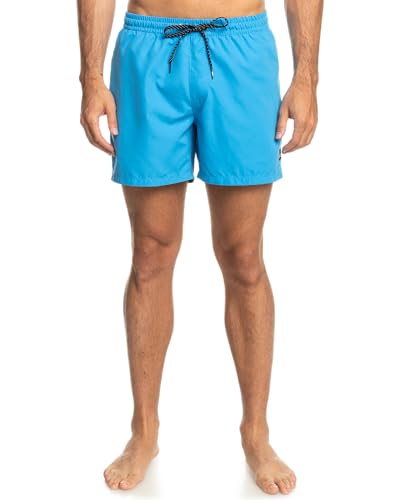 Modelo masculino usando short de natación Quiksilver azul, vista lateral mostrando la longitud y diseño