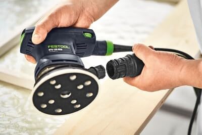 Hands connecting a dust extraction hose to the Festool ETS 125 REQ-Plus sander.