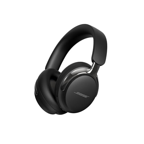 Bose QuietComfort Ultra Headphones 2nd Gen in matte black over-ear design on a busy airport gate seat, the soft-padded ear cups and stitched headband visible, capacitive touch strip on the right cup — PCMag's pick for the most consistently excellent noise cancellation in 2026 with aptX Adaptive codec and Immersive Audio spatial modes