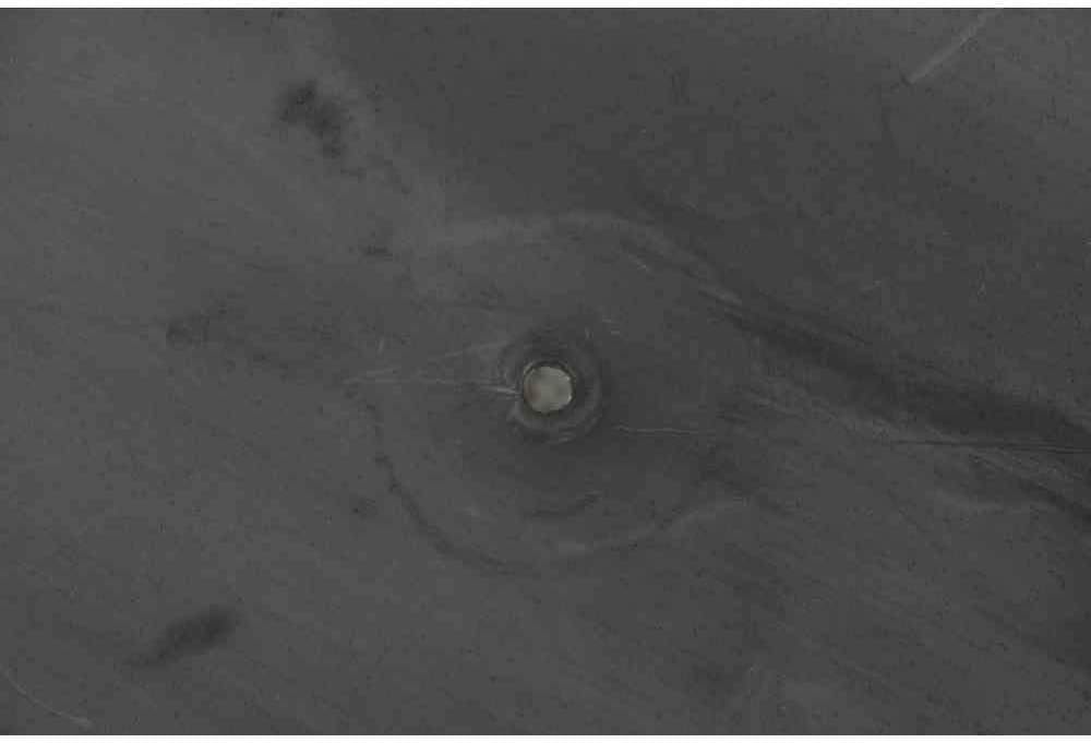 Close-up of a small drainage hole at the bottom center of the fire pit bowl.