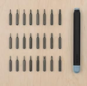 All 25 screwdriver bits and the handle laid out on a wooden surface