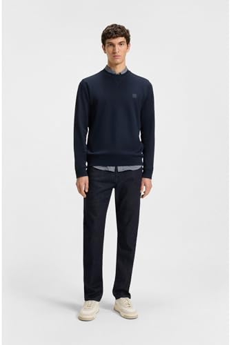 Modelo masculino luciendo pantalón BOSS Re.Maine BC-C combinado con suéter azul, en fondo blanco