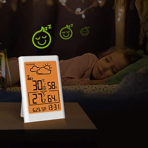 BALDR Wireless Weather Station with a warm orange backlight, shown next to a sleeping child, indicating its gentle illumination suitable for a bedroom environment.