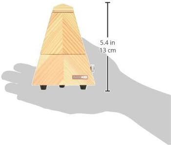 Hand holding the Nikko Metronome Model 610, showing its compact size with dimensions 5.4 inches (13 cm) indicated.