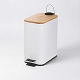 Papelera de pedal rectangular de 5 litros con acabado mate. Tapa de bambú y cuerpo de metal blanco. Cubo interior de polipropileno extraíble con asa. Medidas: 25x14x27 cm.