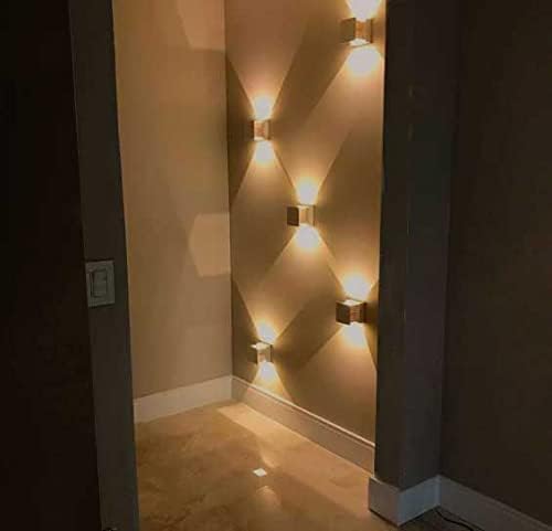 Multiple Interlight Quasar sconces installed on an interior wall, creating a decorative light pattern