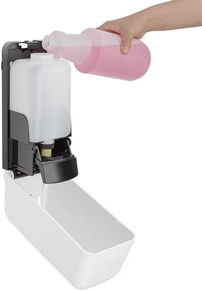 Hand pouring liquid into the Jantex FK385 dispenser reservoir