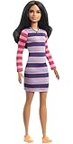 La muñeca Barbie tiene un pecho más pequeño que el del cuerpo original y lleva un colorido vestido de rayas.
