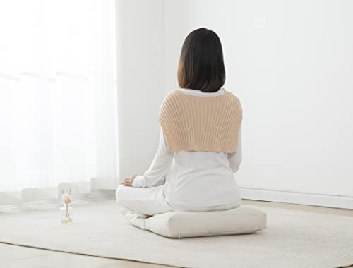 Person in light clothing sitting cross-legged on a white floor cushion in a bright minimal room with sheer curtains.