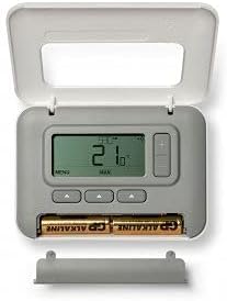 פְּנִימִי view של תרמוסטט Honeywell עם המכסה הקדמי פתוח, שחושף תצוגה דיגיטלית, כפתורי בקרה ותא המכיל שתי סוללות AA.