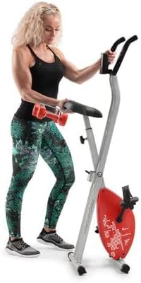 Kvinde står ved siden af en sammenfoldet ProForm X-cykel med håndvægte