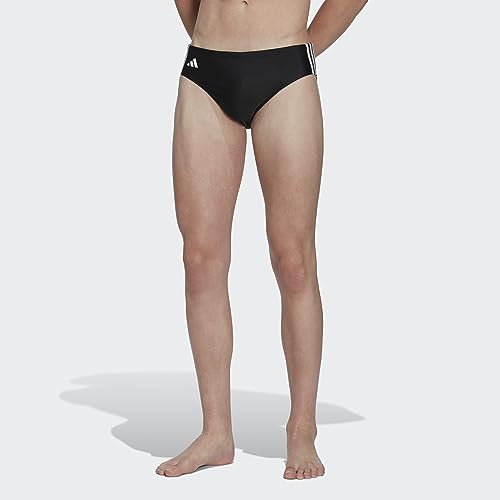 Modelo masculino usando bañador clásico negro de adidas en un fondo gris