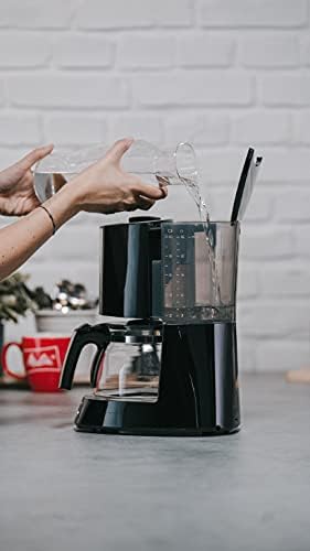 Pouring water into the Melitta coffee machine's water tank.